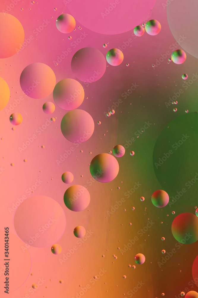 macro of oil mixed with water on colorful red, pink, green and orange background, colourful circles, copy space, vertical macro of oil mixed with water on colorful red, pink, green and orange background, colourful circles, copy space, vertical