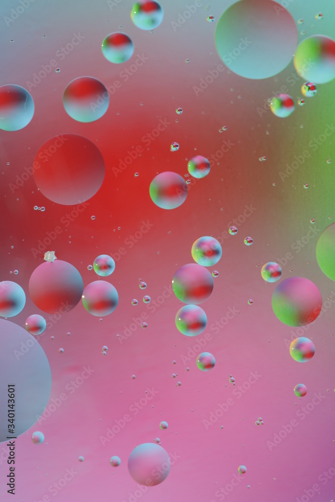 macro of oil mixed with water on colorful red, pink, green, blue background, colourful circles, copy space, vertical macro of oil mixed with water on colorful red, pink, green, blue background, colourful circles, copy space, vertical