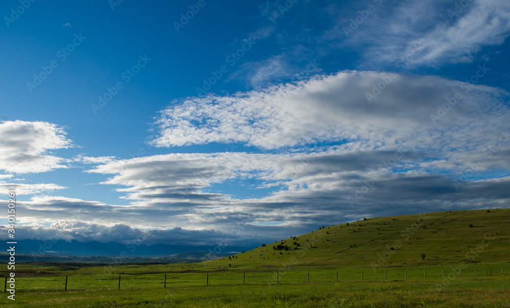 Open Blue Sky with White clouds Green Hill and Fence on Small Farm with Hill on scenic rural farm 