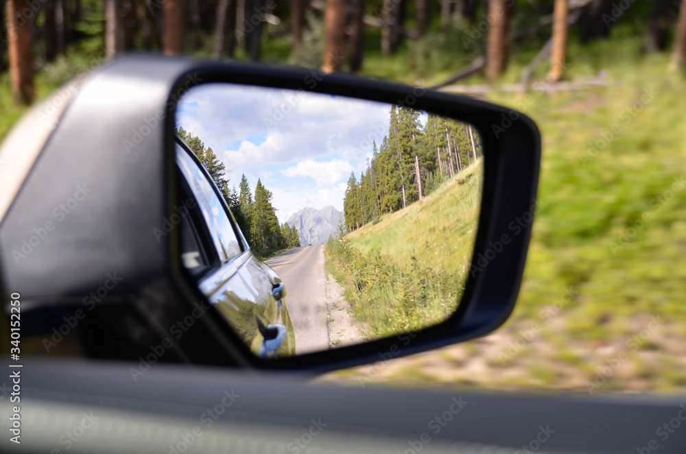 Rare side winnow  of car while driving on local natural road-national park in north america-canada in summer time with sunshine