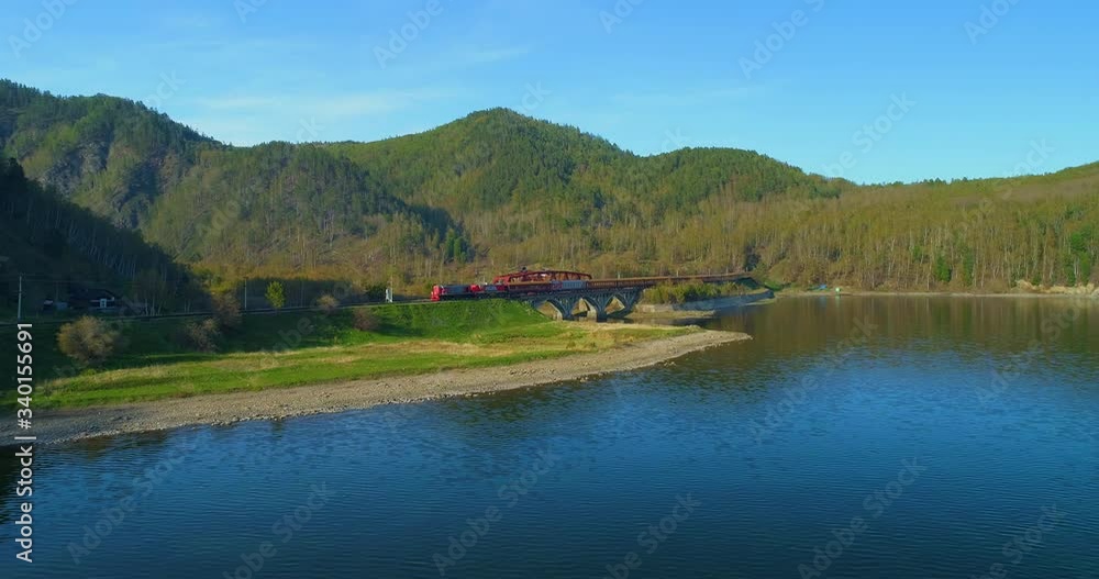 Aerial Lockdown: Long Idle Train While Sun Brightly Shines Above the Nature Filled Area - Lake Baikal, Russia Aerial Lockdown: Long Idle Train While Sun Brightly Shines Above the Nature Filled Area - Lake Baikal, Russia