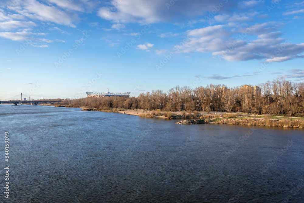 Fototapeta premium Bank of River Vistula and National Stadium seen from Lazienkowski bridge in Warsaw, capital city of Poland