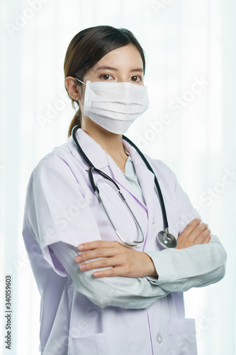 Portrait of a young woman doctor wearing medical mask with stethoscope in uniform.