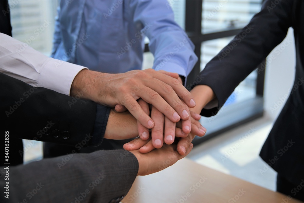 Obraz premium Business teamwork colleague top view putting join hands together for company office project concept with selective focus