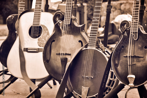 Acoustic folk and bluegrass instruments on Instrument Stands. Guitar, banjo, mandolin, bass mandolin. photo