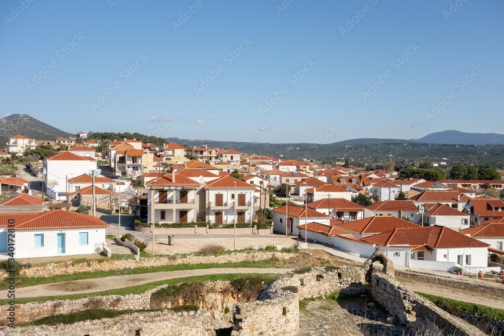 Cityscape of suburb in Methoni city, Greece with small white houses with red roofs