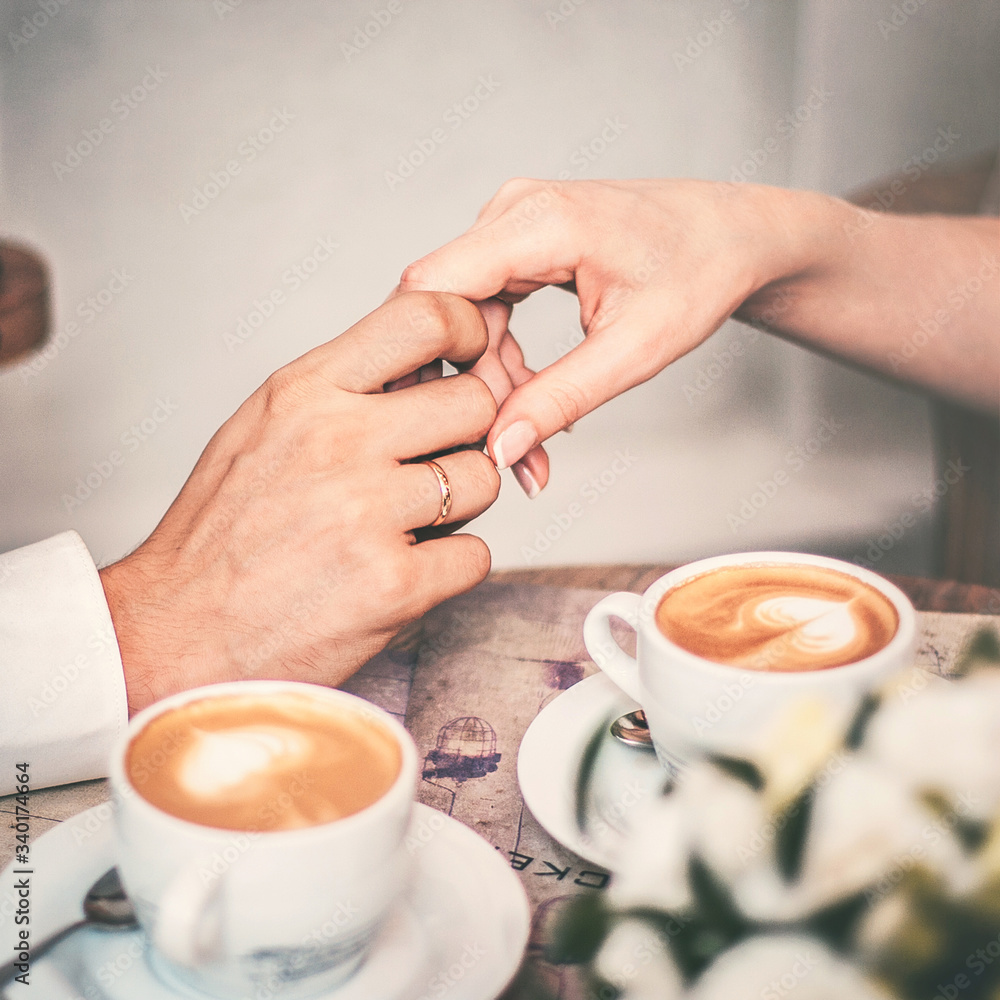 Loving couple drink coffee after the wedding. Hands newlyweds Loving couple drink coffee after the wedding. Hands newlyweds