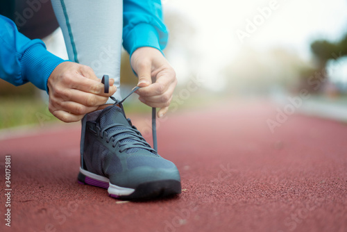 Sporty woman ties her shoes before jogging