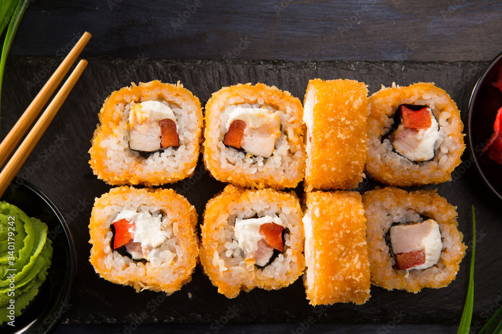 Set of fried sushi rolls with wasabi and ginger on a black background. Japanese oriental cuisine Set of fried sushi rolls with wasabi and ginger on a black background. Japanese oriental cuisine