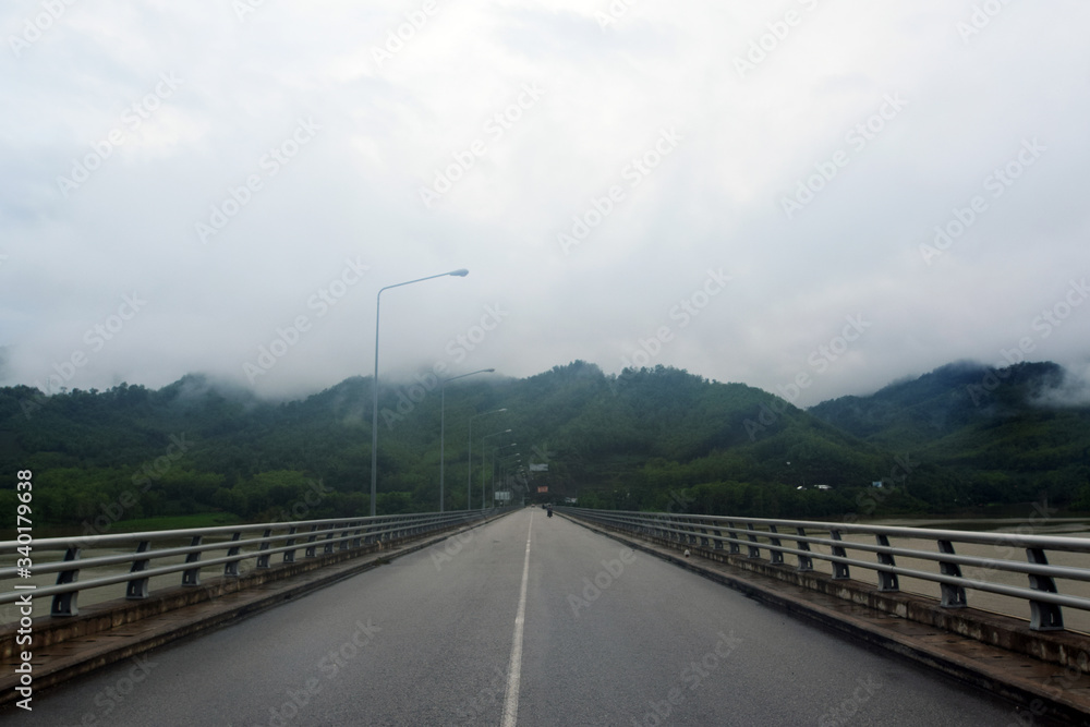 Large river bridge, asphalt road, river, mountain and sky road view Large river bridge, asphalt road, river, mountain and sky road view