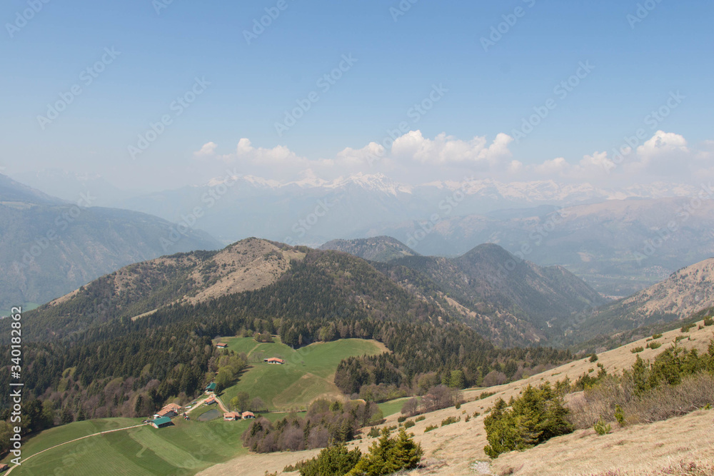 Fototapeta premium Rural contryside in mountains. Agricultural fields on hills with mountains on background.
