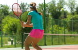 Girl plays tennis on the court in the park