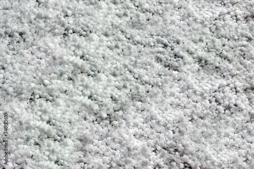 grains of hail lie on the surface of the soil after a heavy snowfall, background and texture. Anomaly weather in Russia during quarantine