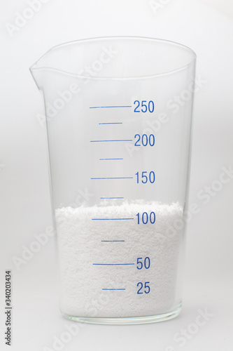 glass laboratory jar with samples of white synthetic rubber on a white background