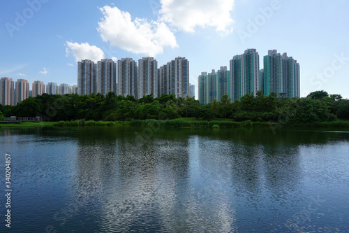 scenic view of city skyline, buildings reflected in water in Hong Kong wetland park