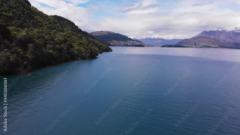 Lone Kayak along Shore, Cloudy Day, Trees, Mountain, Lake Wakatipu, New Zealand Lone Kayak along Shore, Cloudy Day, Trees, Mountain, Lake Wakatipu, New Zealand