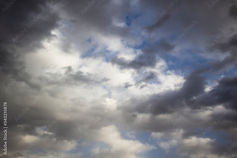 Clouds in the blue sky. A stunning gray sky. The storm is approaching. A beautiful clouds against the blue sky background. Amazing cloud pattern in the sky.