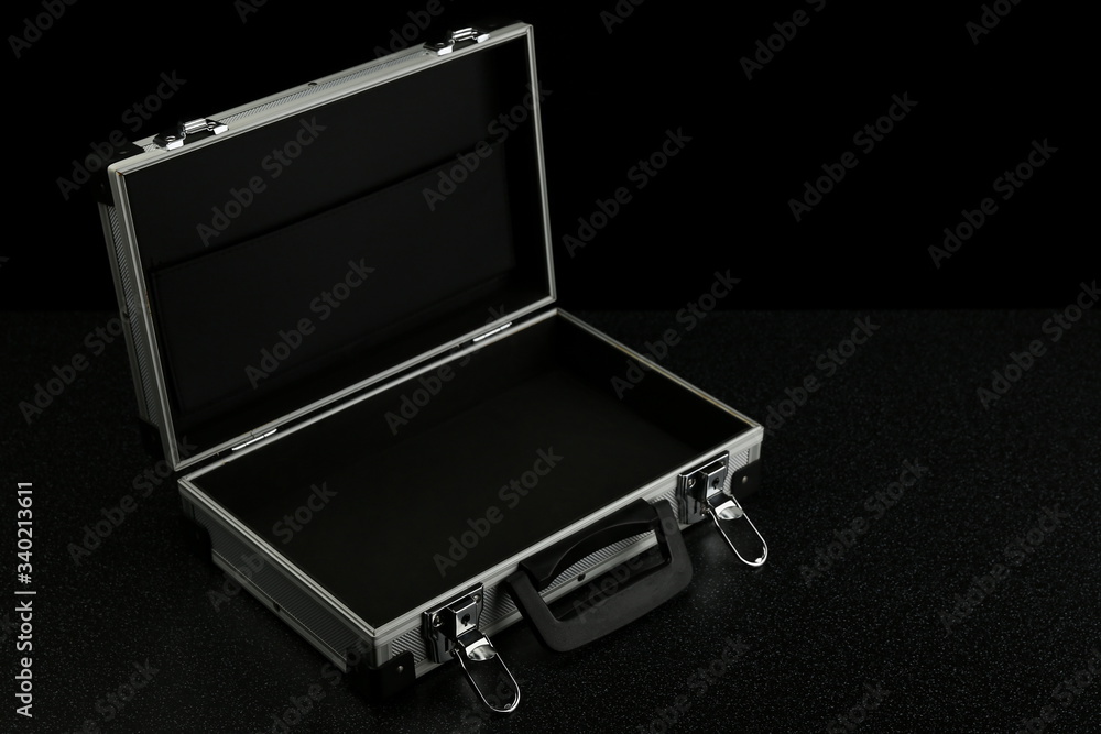 aluminum suitcase on a black background. stylish aluminum case on a dark background with copy space aluminum suitcase on a black background. stylish aluminum case on a dark background with copy space