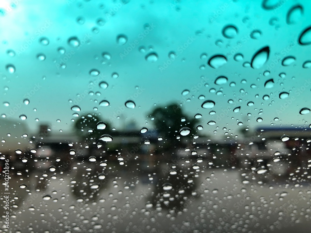 Rain falling on car windshield,drive car on street in city at heavy rain storm,blurred traffic light. Rain falling on car windshield,drive car on street in city at heavy rain storm,blurred traffic light.