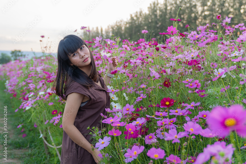 Asian cute young woman joyful, smiling with pink cosmos background. Asian cute young woman joyful, smiling with pink cosmos background.