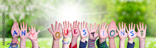 Children Hands Building Colorful Word Any Questions. Sunny Green Grass Meadow As Background