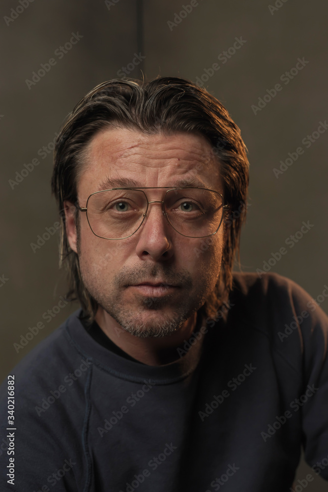 Studio portrait of a man wearing eyeglasses.