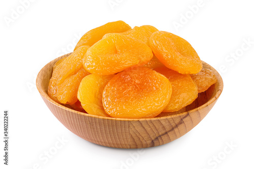 Dried apricots in wooden bowl isolated on white background with clipping path and full depth of field.