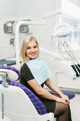 Smiling female patient looking at camera at dental clinic