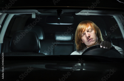 Canvas Print Young man dozing off while driving at night