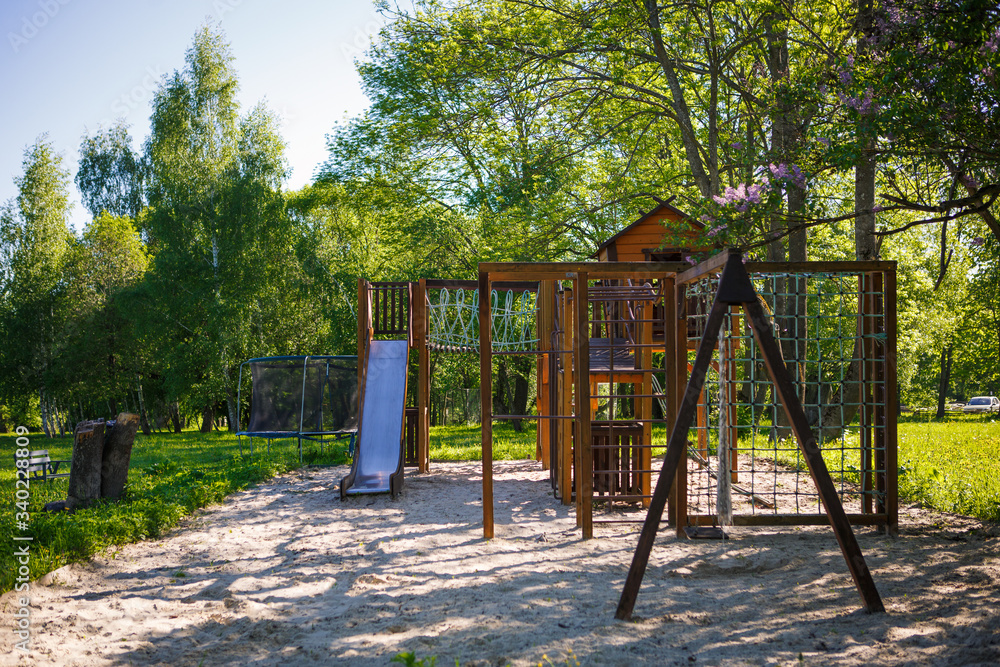 Wooden children's Playground in nature in the eco-Park. Ladder, a swing, a Playhouse for children made of wood in rustic style Wooden children's Playground in nature in the eco-Park. Ladder, a swing, a Playhouse for children made of wood in rustic style