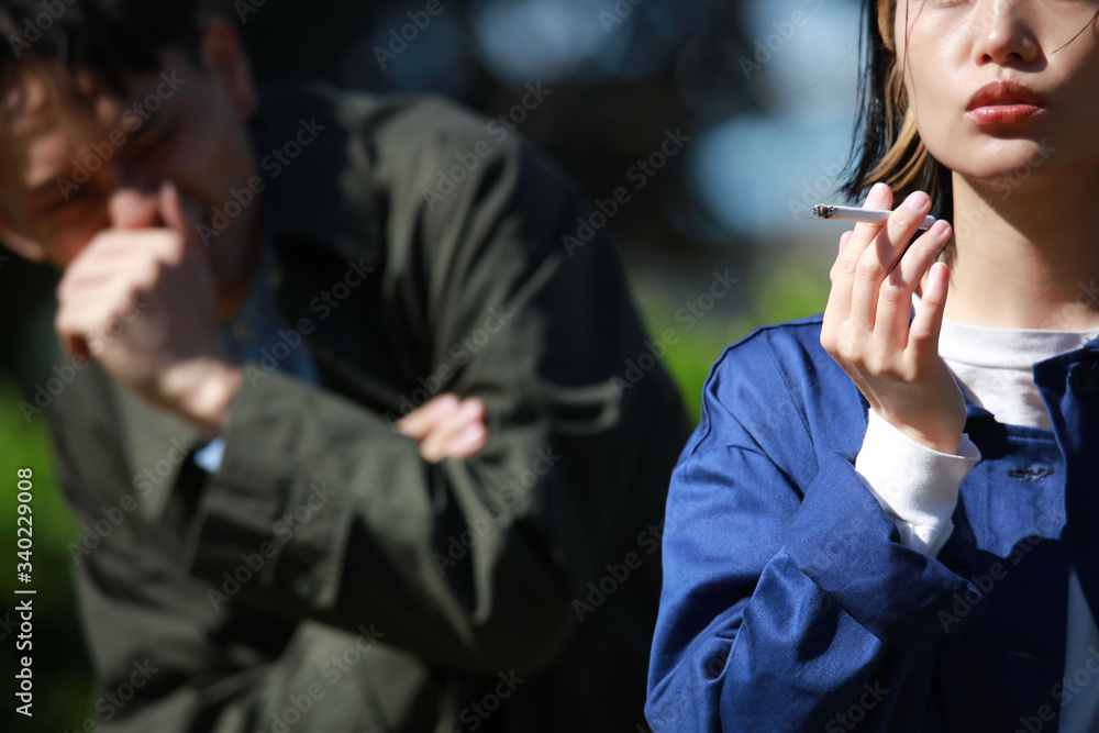 タバコを吸う女性と嫌がる男性 Stock Photo Adobe Stock