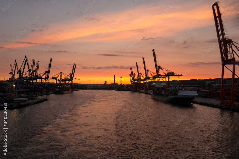 Harbor area with many cranes, in evening light, in Gdynia, Poland.