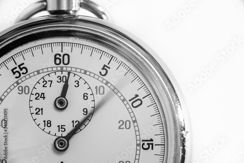 A black and white close up macro view of a pocket watch. Long exposure blurred the second hand giving an impression of passage of time