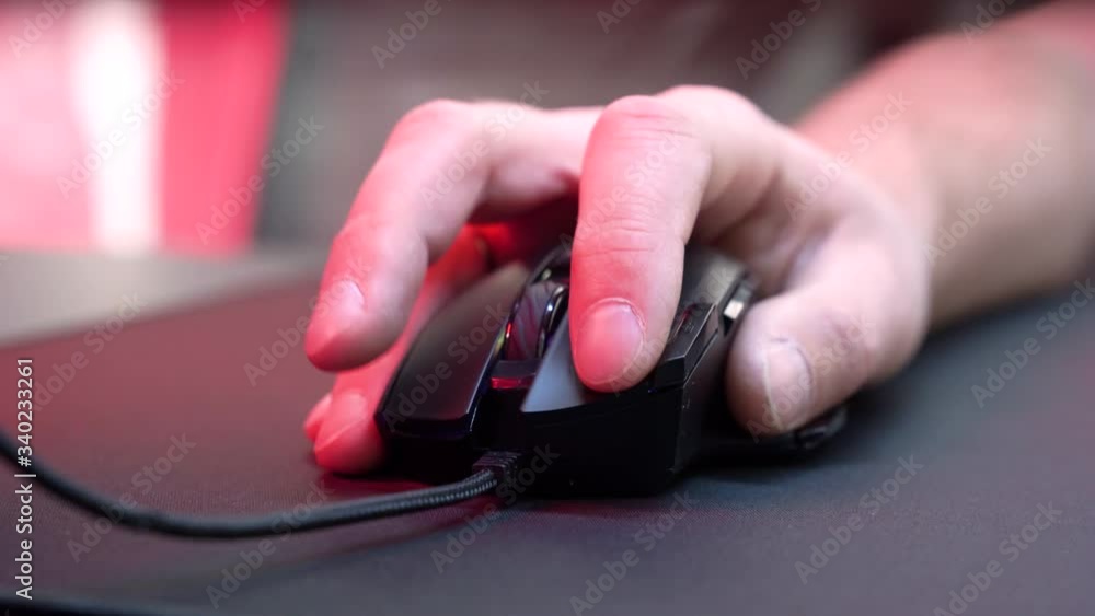 Gaming Device Mouse. A gamer is playing in a computer club. In the frame, the hand of a gamer and a gaming mouse. Red and violet colors. ESports competitions.
Gaming Device Mouse. A gamer is playing in a computer club. In the frame, the hand of a gamer and a gaming mouse. Red and violet colors. ESports competitions.