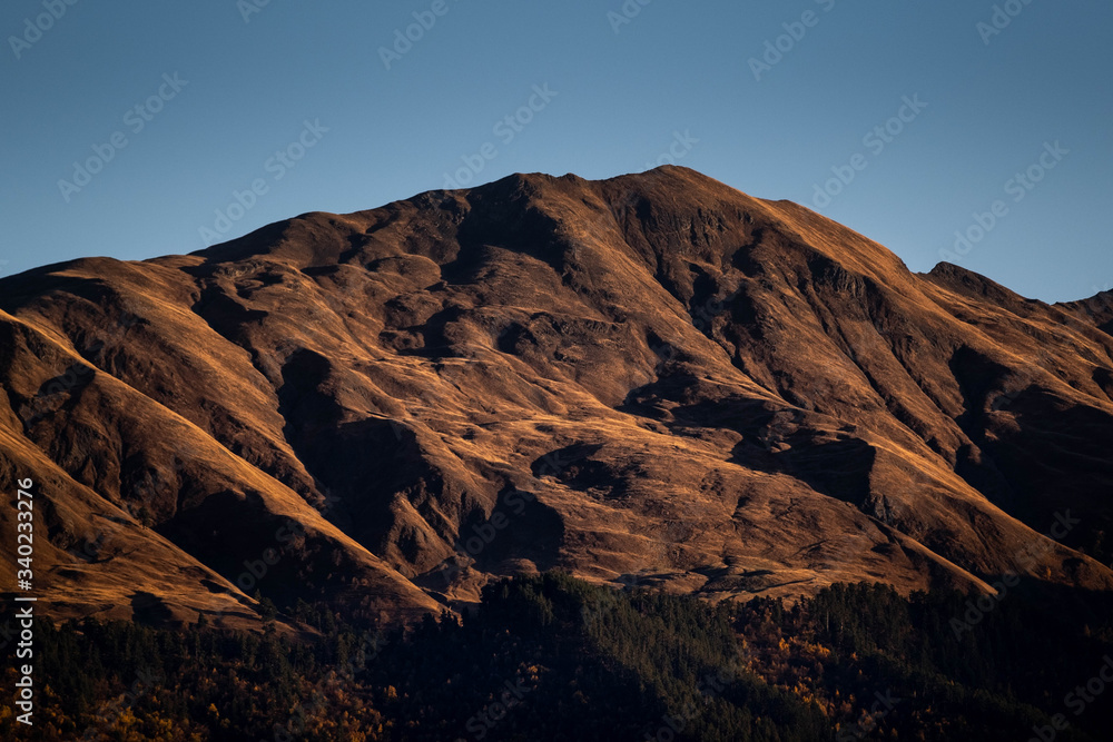 A mountain is lit by the setting sun in the Tusheti region.