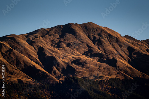 A mountain is lit by the setting sun in the Tusheti region.