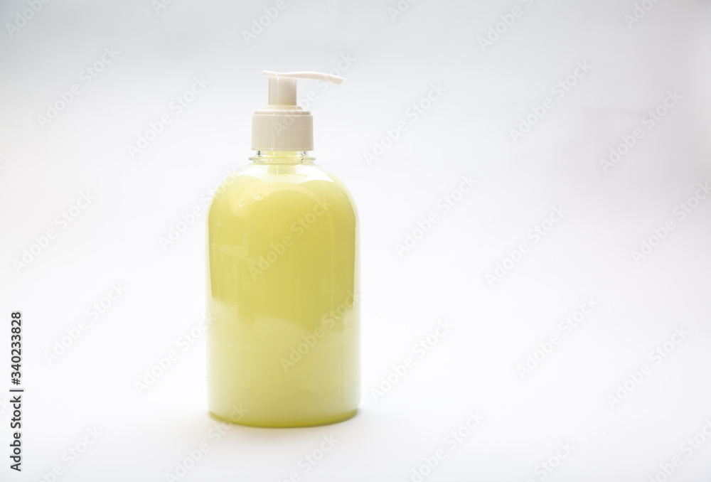 plastic bottle of yellow antiseptic soap with dispenser on a white background plastic bottle of yellow antiseptic soap with dispenser on a white background