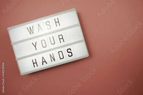 Flat lay Wash Your Hands word in light box with space coy on pink background
