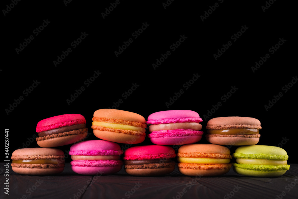 Stack of french colorful macaroons in row isolated on black background Stack of french colorful macaroons in row isolated on black background