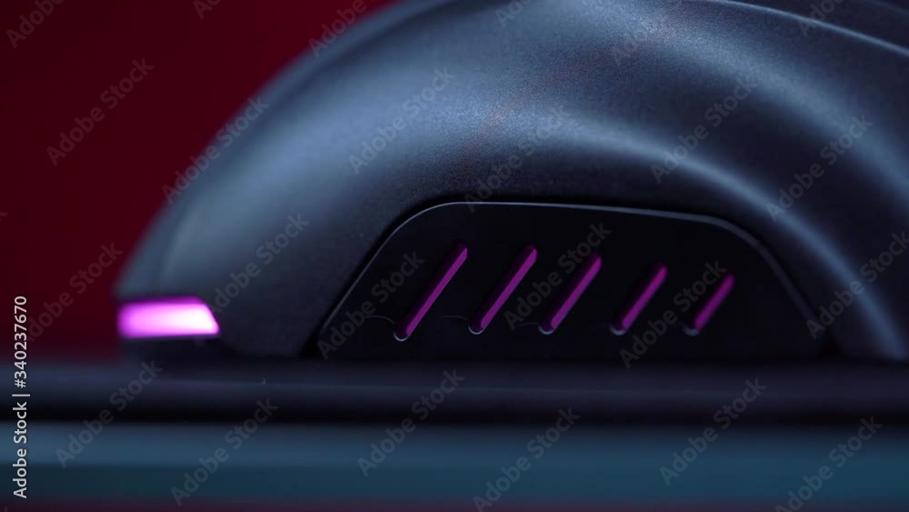 Gaming Device Mouse. A gamer is playing in a computer club. In the frame, the hand of a gamer and a gaming mouse. Red and violet colors. ESports competitions.
Gaming Device Mouse. A gamer is playing in a computer club. In the frame, the hand of a gamer and a gaming mouse. Red and violet colors. ESports competitions.