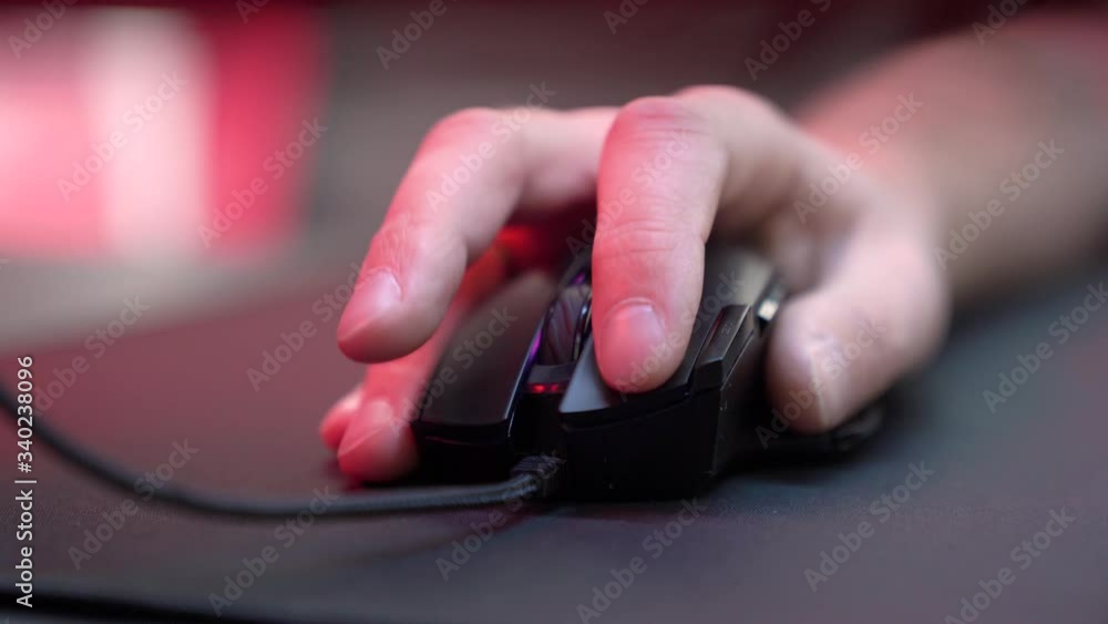 A gamer is playing in a computer club. In the frame, the hand of a gamer and a gaming mouse. Red and violet colors. ESports competitions.
A gamer is playing in a computer club. In the frame, the hand of a gamer and a gaming mouse. Red and violet colors. ESports competitions.