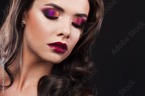 Gorgeous young brunette in a chic evening look. Scarlet lips and eye shadow,