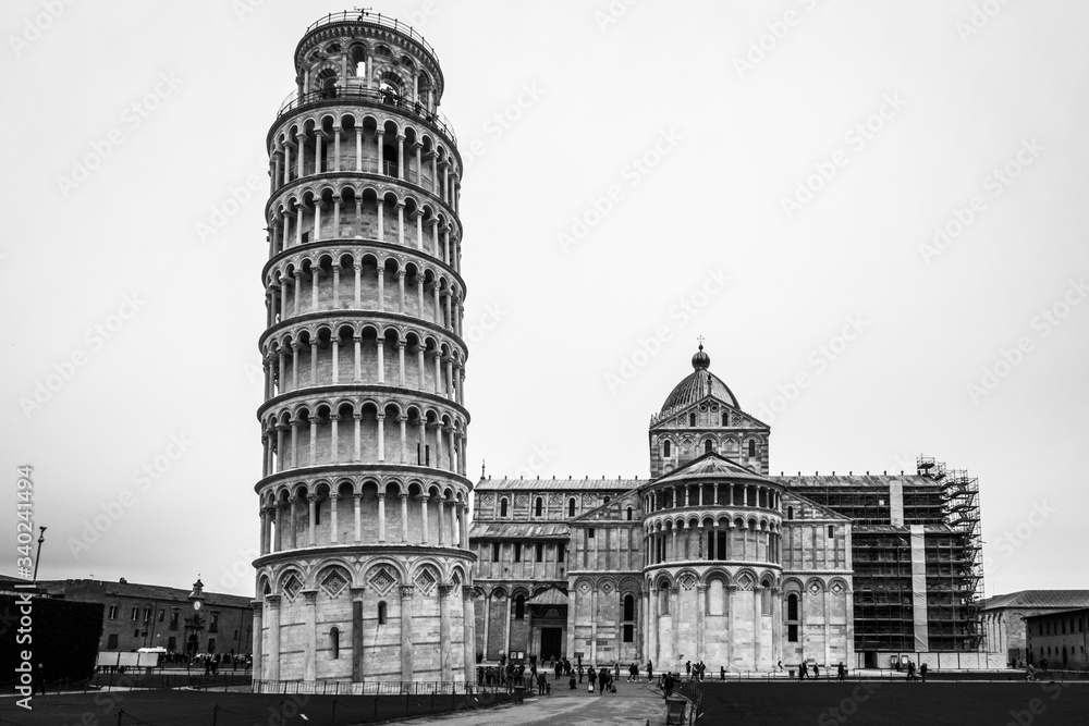 Black and white image of the Leaning Tower of Pisa (Torre di Pisa) and Pisa Cathedral at Miracle Square, Tuscany.