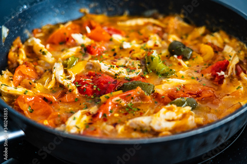 Chicken ragout with tomatoes, pepper and onion in cooking pan