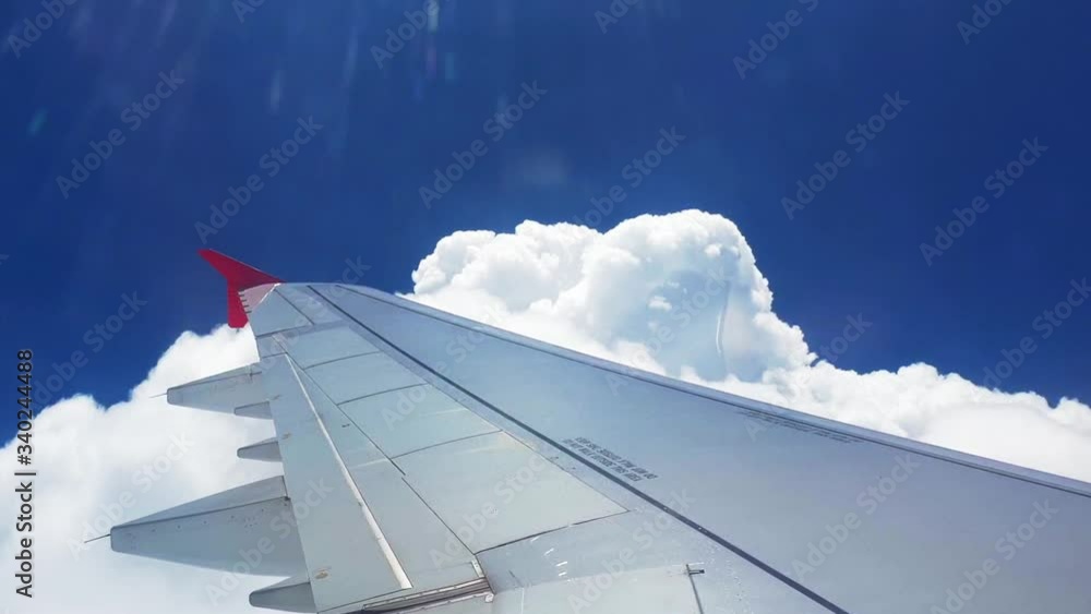 Airplane flight. Wing of an airplane flying above the clouds with sunset sky. View from the window of the plane. Airplane, Traveling by air Airplane flight. Wing of an airplane flying above the clouds with sunset sky. View from the window of the plane. Airplane, Traveling by air