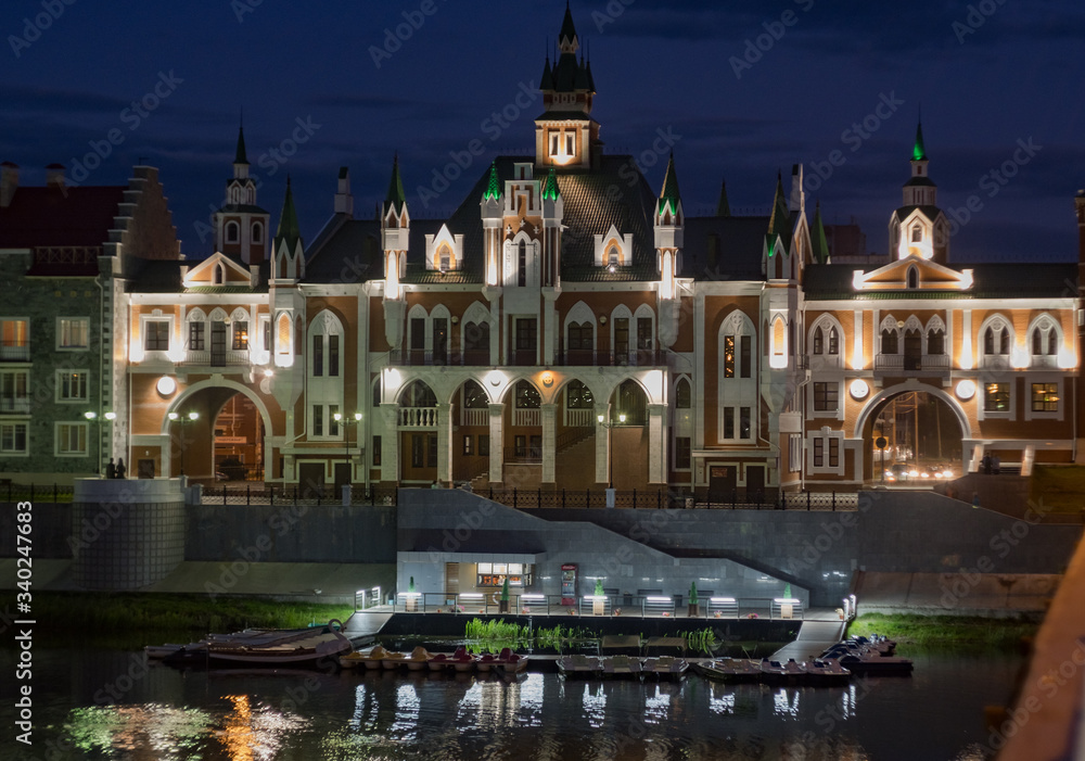 Fototapeta premium Central registry office and boat station on the Bruges waterfront in Joshkar-Ola, evening 2019.