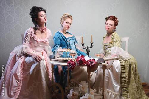 Photography Three beautiful ladies in lavish dresses at a party in a historical setting