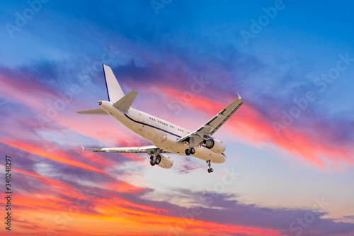 Commercial airplane flying in beautiful sky at sunset,travel concept.