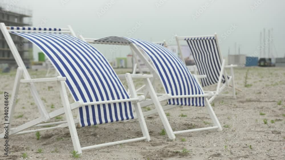 Couple of Sun Chairs on an empty beach, waving in the wind. Couple of Sun Chairs on an empty beach, waving in the wind.