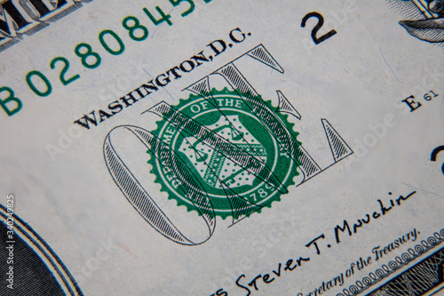 macro photography of a 1 US dollar banknote. Ultra close up of a one American dollar note. US dollar is the world currency. The lettering ONE with the green seal on the front side of the banknote
